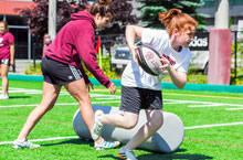 Joueuse de rugby lors du camp, portant le ballon.